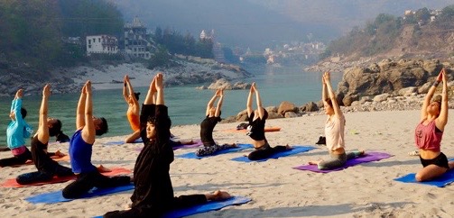 practicando yoga en la playa